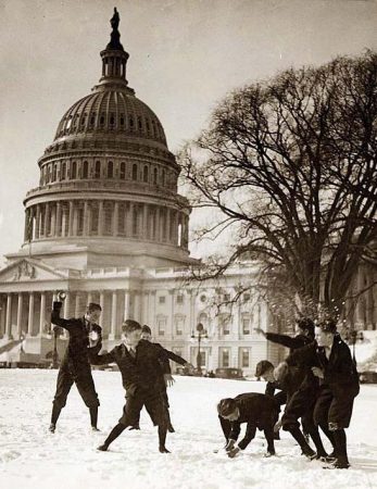 Old photo of pages playing in snow in front of US Capitol